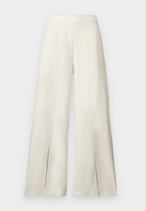 Wijd uitlopende, roomkleurige broek met hoge taille en voorste splitten bij de zoom, getoond tegen een effen achtergrond.