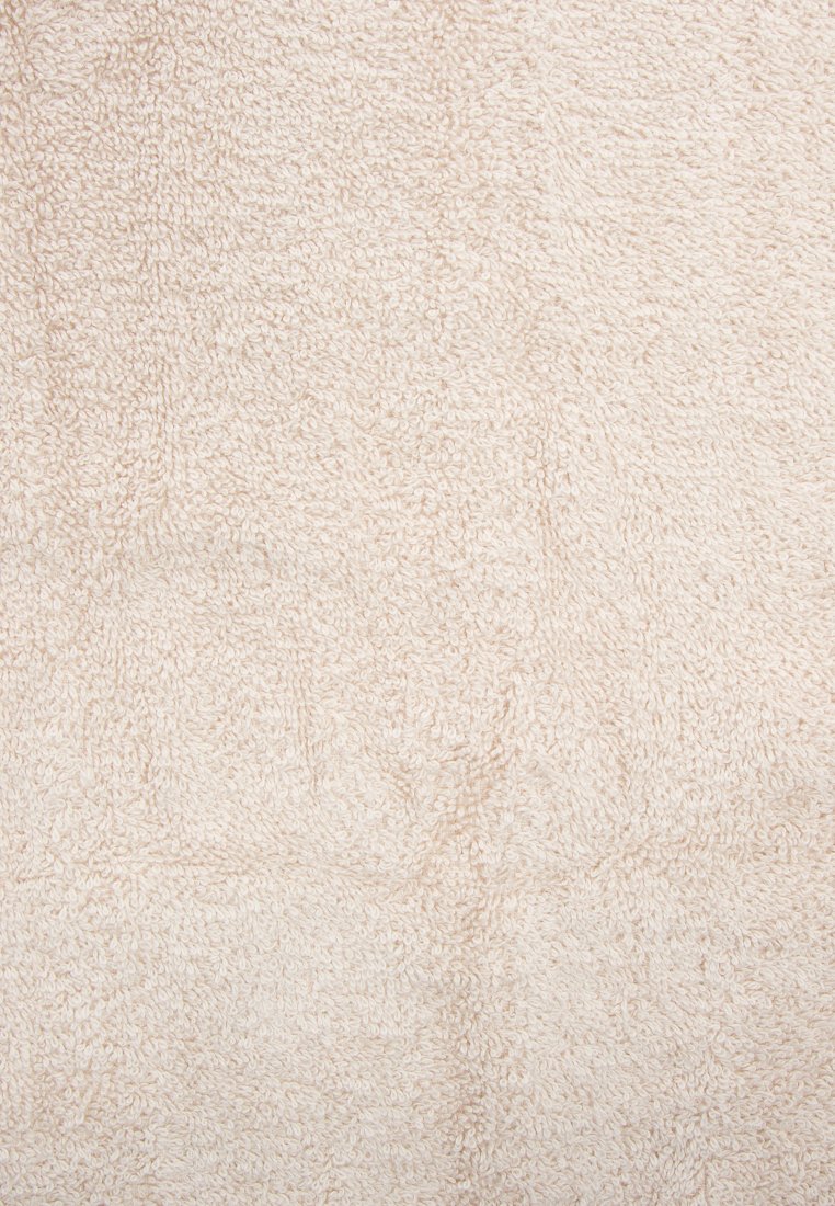 Beige strukturierteter Stoff mit einer weichen, flauschigen Oberfläche, die an Frottier ähnelt, und einem einheitlichen Webmuster.
