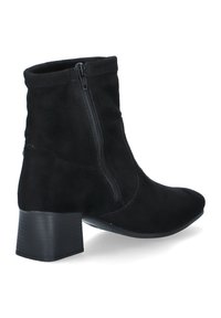 Bottes noires en daim à la cheville avec une fermeture éclair sur le côté, un bout effilé et un talon épais. Présente une texture lisse et un design simple et moderne.