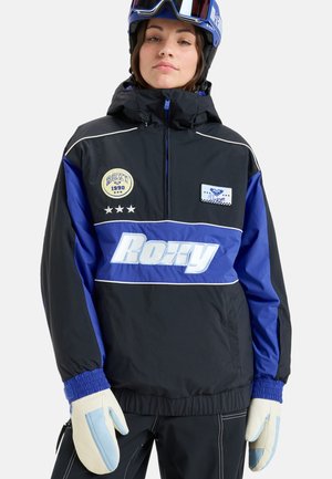 Veste de ski noire et bleue avec col zippé, logos et rayures blanches contrastantes ; accompagnée de moufles de couleur crème.