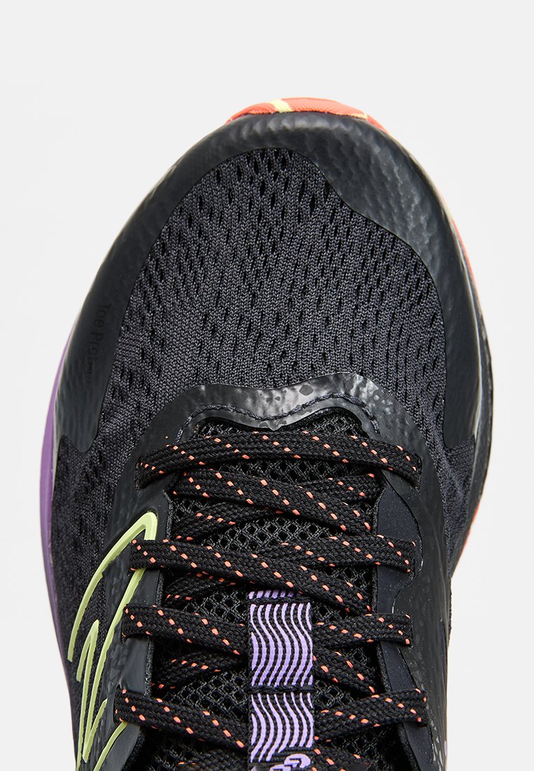 Scarpa da ginnastica nera con una tomaia in rete traspirante, lacci arancioni a contrasto e una suola testurizzata con accenti viola sul tallone.