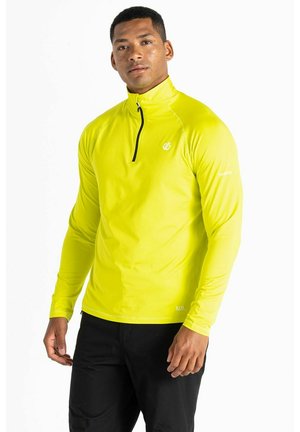 Camisa deportiva de manga larga amarilla con cuello con cremallera, hecha de un material ligero. Presenta un pequeño logo en el pecho y en la manga.