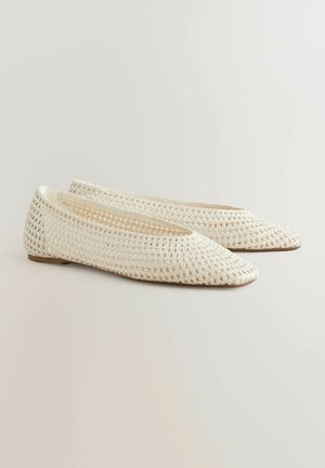 Hvide vævede flade sko med spids tå, der har et tekstureret, åbent design og en glat indvendig foring. Lavprofil sål for fleksibilitet.