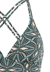 Driehoekige bikinibovenkant met groene en perzikkleurige geometrische patronen en dunne bandjes die kruisen aan de achterkant.