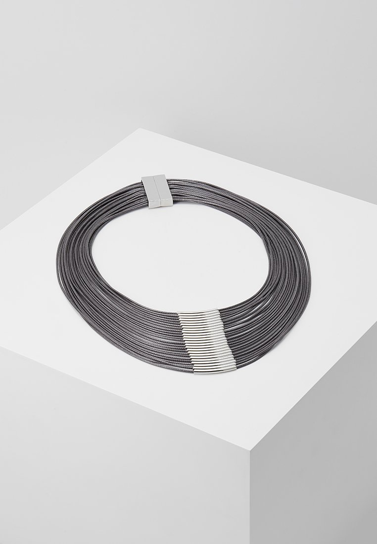 Collier à plusieurs brins en fil métallique gris foncé avec un fermoir argenté brillant et des bandes d'accent, présentant une texture lisse et flexible.