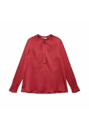Chemisier long à manches longues en satin rouge avec un col rond, un léger pli à l'avant et des poignets légèrement évasés aux manches.