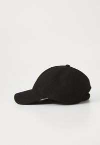 Black baseball cap made of wool-like material with a curved brim, five ventilation holes, and a subtle logo on the front.