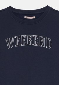 Marinasti pulover z belim napisom "WIKEND," okroglim izrezom, rebrastimi robovi in mehkobo. Blagovna znamka vidna znotraj.