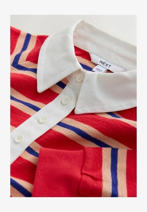 Csíkos póló ing piros, őszibarack és kék színekben, fehér gallérral, három gombbal az elején és sima textúrával.