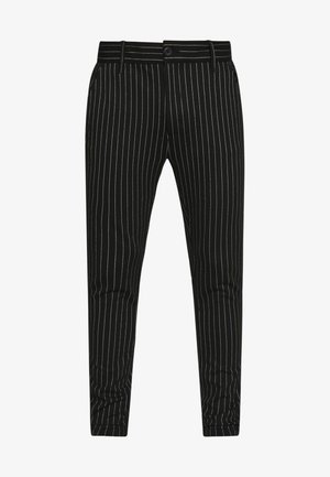 Calças pretas riscas com riscas brancas verticais, um design slim fit, e um fecho de botão com passantes para cinto para ajuste do tamanho.