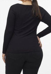 Maglietta nera a maniche lunghe con scollo a giro. Tessuto a trama, design aderente e finitura liscia. La vista posteriore mostra una leggera curva.