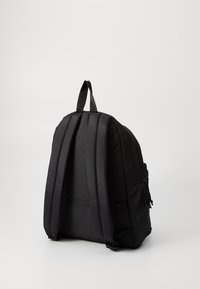 Sac à dos noir avec des bretelles rembourrées, un dos texturé, une poignée supérieure et une poche latérale zippée. Design simple, tissu léger et intérieur spacieux.
