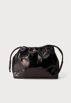 Kleine schwarze, glänzende Ledertasche mit Ziehbändern und kurzen Griffen vor einem hellgrauen Hintergrund.