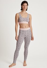 Merk bh en legging set in lichtroze en wit, met een bloemmotief. De stof is zacht met een aansluitend ontwerp en een rekbare tailleband.