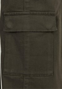 Pantalon cargo vert olive avec une grande poche plaquée sur la cuisse, fabriqué en tissu coton durable avec une texture lisse et des coutures visibles.