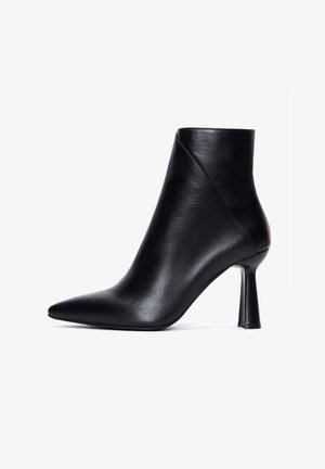 Bottine en cuir noir avec un bout pointu, un design élégant et un talon aiguille. Texture lisse avec un léger éclat.