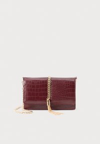 Clutch in ecopelle coccodrillo bordeaux con tracolla in catena dorata e dettagli con frange su sfondo bianco.