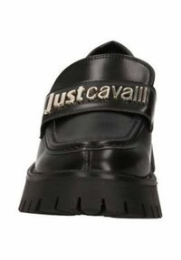 Scarpa in pelle nera con punta rotonda, caratterizzata da una larga fascetta con la scritta "Just Cavalli" in argento. Suola testurizzata con scanalature profonde.