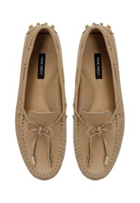Beige Leder-Mokassin-Pantoffeln mit runder Zehenform, dekorativem Bogen und metallischen Akzenten. Mit perforierter Innensohle und detaillierten Nähten.