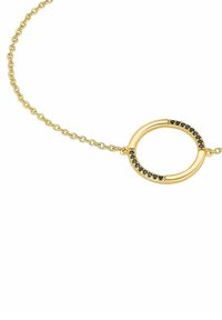 Collana in oro con pendente circolare decorato con piccole pietre nere, che mette in risalto una finitura liscia e lucida e una delicata texture.