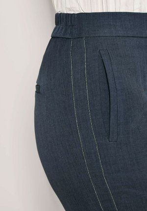 Donkerblauwe broek met een gestructureerde afwerking, voorzien van een brede elastische tailleband, zijzakken en contrasterende lichte stiksels langs de naden.