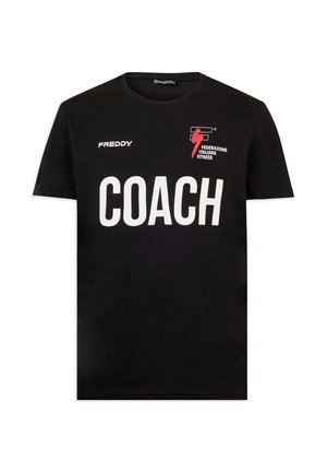 T-shirt noir à manches courtes avec "COACH" en grandes lettres blanches, logo "FREDDY" sur la poitrine gauche et emblème de la Fédération Italienne de Fitness sur la poitrine droite.