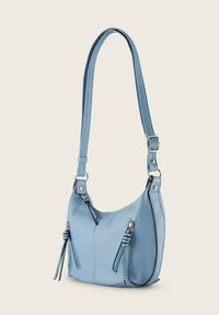 Light blue leather shoulder bag with a curved design, two zippered pockets, and textured surface. Features adjustable strap and silver hardware.