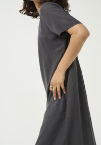 Hamei harmaat polveen asti ulottuva mekko, joka on valmistettu kevyestä kankaasta. Siinä on lyhyet hihat, löysä mukavuus ja kontrastoiva sivupaneeliyksityiskohta.