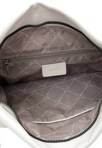 Das Innere der weißen Lederhandtasche hat ein graues Futter mit einem komplizierten Muster und einer Reißverschlusstasche. Beinhaltet ein Einschubfach mit Etikett.