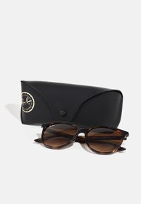 Occhiali da sole Ray-Ban con lenti gradienti marroni, montatura a tartaruga nera e marrone. Include una custodia nera texturizzata con logo oro.
