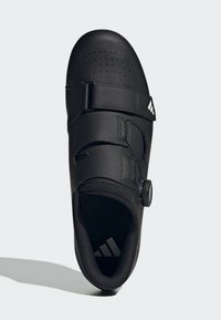 Zapato de ciclismo negro con parte superior lisa, perforaciones para ventilación, cierres de doble correa y un dial circular para ajuste regulable.