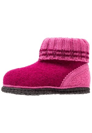 Kraftigt pink uldhjemmesko med tyk, ribbet ankelmanchet, mørkerosa stribe, tekstureret sål og dekorative syninger, vist fra siden.