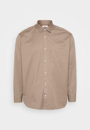 Camisa de manga larga color beige con cuello, un bolsillo en el pecho y una textura sutil. Hecha de una tela ligera, cuenta con botones blancos.