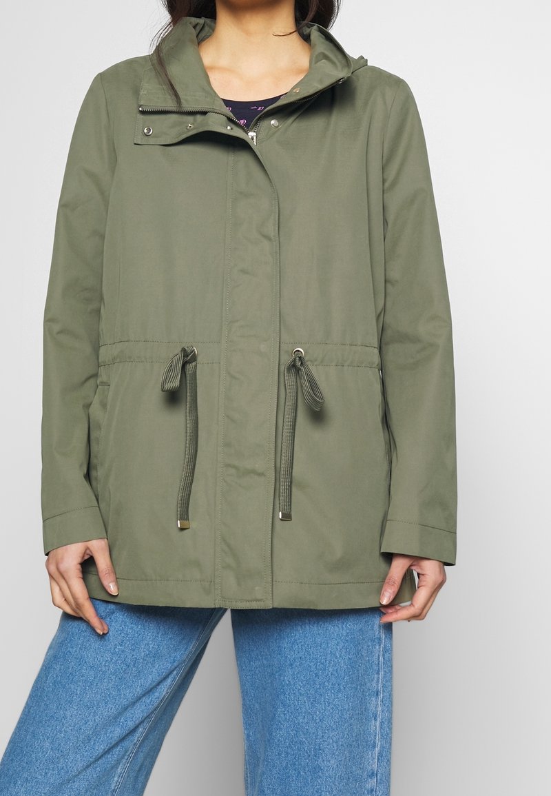 Olivově zelená nepromokavá bunda s kapucí, stahovací pas, kovové patentky a dlouhé rukávy; hladká, lehká látka.