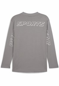 Harmaa pitkähihainen t-paita, joka on valmistettu puuvillasta. Takana on valkoinen teksti "SPORTS" ja molemmissa hihoissa lukee "PUMA". Pyöreä pääntie ja rento malli.
