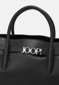 Musta nahkainen käsilaukku, jossa on kaksi pyöreää kahvaa, varustettu hopeisella "JOOP!"-logolla ja tekstuuripinnalla.