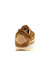 Baskets en daim marron avec une tige texturée, dotées d'un onglet de talon en cuir beige et d'une semelle intermédiaire blanche. Logo arrière embossé sur l'onglet.