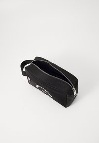 Borsa da toilette rettangolare nera con una texture liscia, zip argento e una maniglia laterale. Presenta testo bianco su un lato.