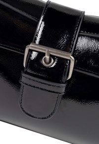 Borsa in pelle patent nera con finitura lucida, dotata di fibbia e tracolla in metallo, texture liscia e forma strutturata.