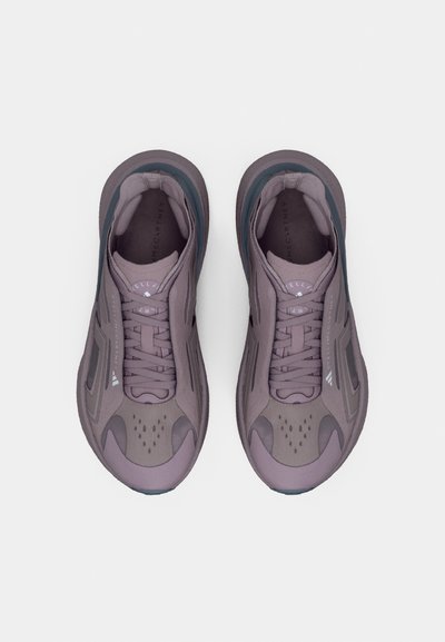 Μοβ αθλητικά παπούτσια με υφασμένο επάνω μέρος, εργονομικό σχεδιασμό και αντίθετες τιρκουάζ λεπτομέρειες. Διαθέτουν έντονη δέση κορδονιών και οπές αερισμού.
