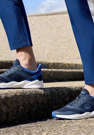 Blaue und schwarze Sportschuhe besitzen ein Obermaterial aus Mesh, eine Gummisohle und eine gepolsterte Ferse, kontrastiert mit einer weißen Sohle und blauen Akzenten.