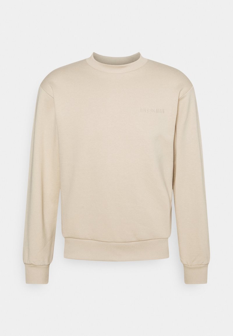 Beige sweatshirt med rund hals, långa ärmar, ribbade muddar och midjeresår. Har subtil prägling med varumärket på framsidan. Slät textur.