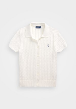 Krátký rukáv, bílý kardigan z pletené tkaniny s límcem, předním zapínáním na knoflíky, žebrovaným lemem a malým modrým logem na levé části hrudi.