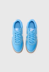 Sinised Nike tossud on varustatud tekstuurse kangasülemisega, valge brändinguga ja kummise kummitaldiga. Klassikaline madala profiiliga disain ja lipsu sulgemine.