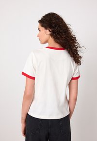 Maglietta bianca in cotone con maniche corte rosse e scollo, caratterizzata da un'orlo arrotondato e una vestibilità comoda.