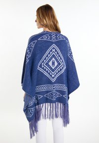Poncho albastru țesut cu modele geometrice în albastru deschis, având detalii cu franjuri la tiv. Fabricat dintr-un material moale, texturat.