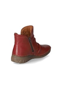 Stivali alla caviglia in pelle rossa con una tomaia testurizzata, chiusura con cerniera e suola in gomma marrone, caratterizzati da dettagli di cucitura visibili.