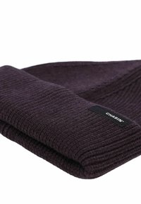 Gorro de punto de color púrpura oscuro con textura acanalada y puño doblado. Presenta una etiqueta negra cosida con el nombre de la marca "CHASIN'."