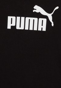 Čierne bavlnené tričko s veľkým bielym logom "PUMA" a grafikou skáčucej mačky, s jemnou textúrou a klasickým okrúhlym výstrihom.