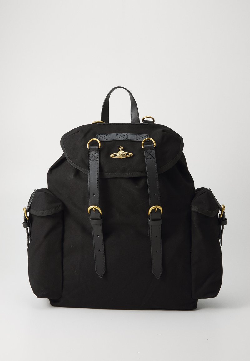 Mochila preta em lona com acabamentos em couro, aba superior, ferragens em tom de ouro, dois bolsos laterais e alças ajustáveis. Forma retangular.